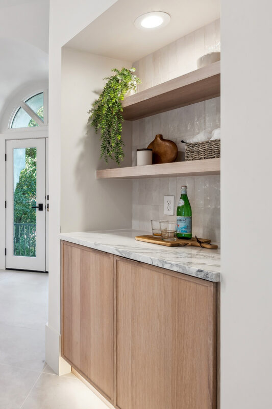 Light brown stained master bedroom cabinet with floating shelves.
