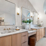 Double light brown bathroom vanities with powder desk in between.