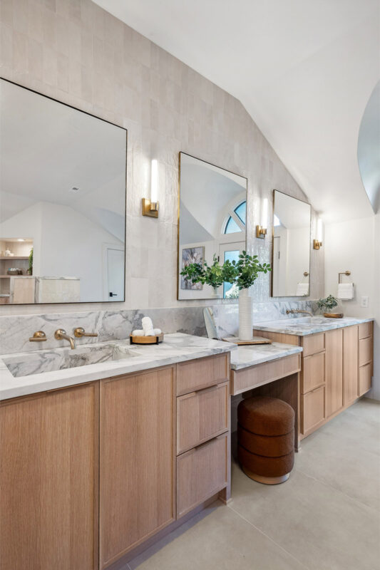 Double light brown bathroom vanities with powder desk in between.