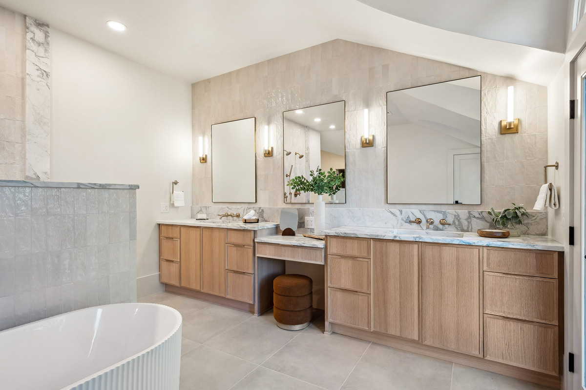Double light brown bathroom vanities with powder desk in between.