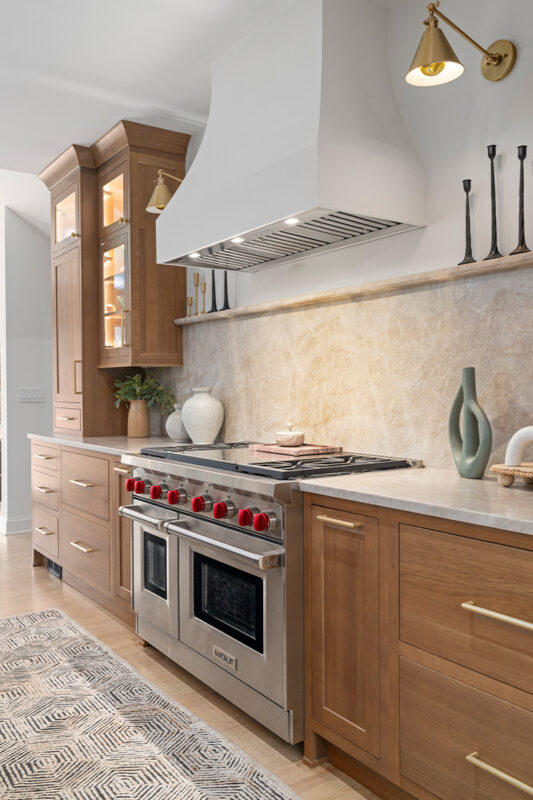 Stained white oak kitchen with a white hood.