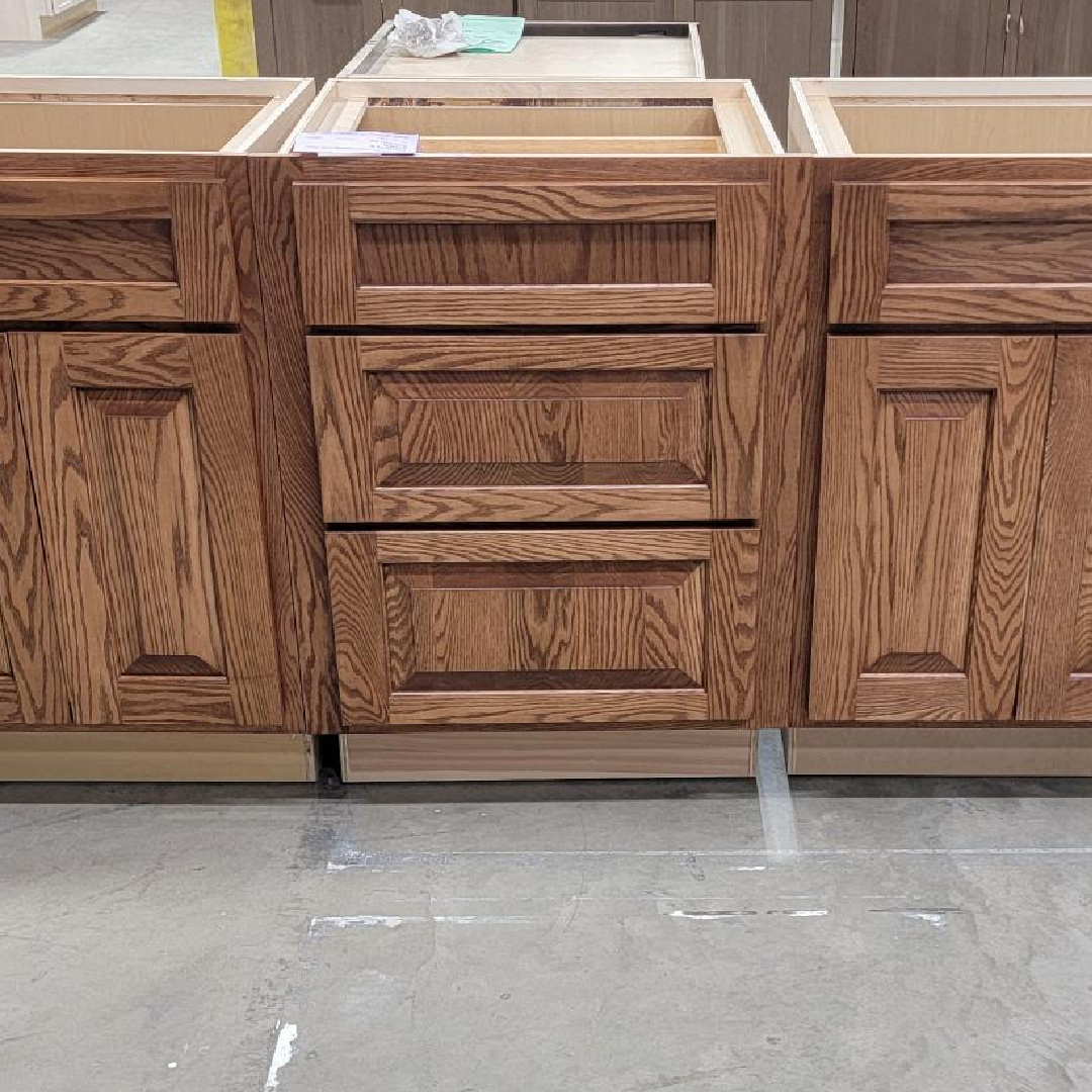 Light brown stained base cabinets in a warehouse setting