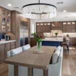 Brown-stained kitchen cabinets and dining table with a blue pained island.