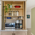 Open pocket doors showing appliances behind the doors.