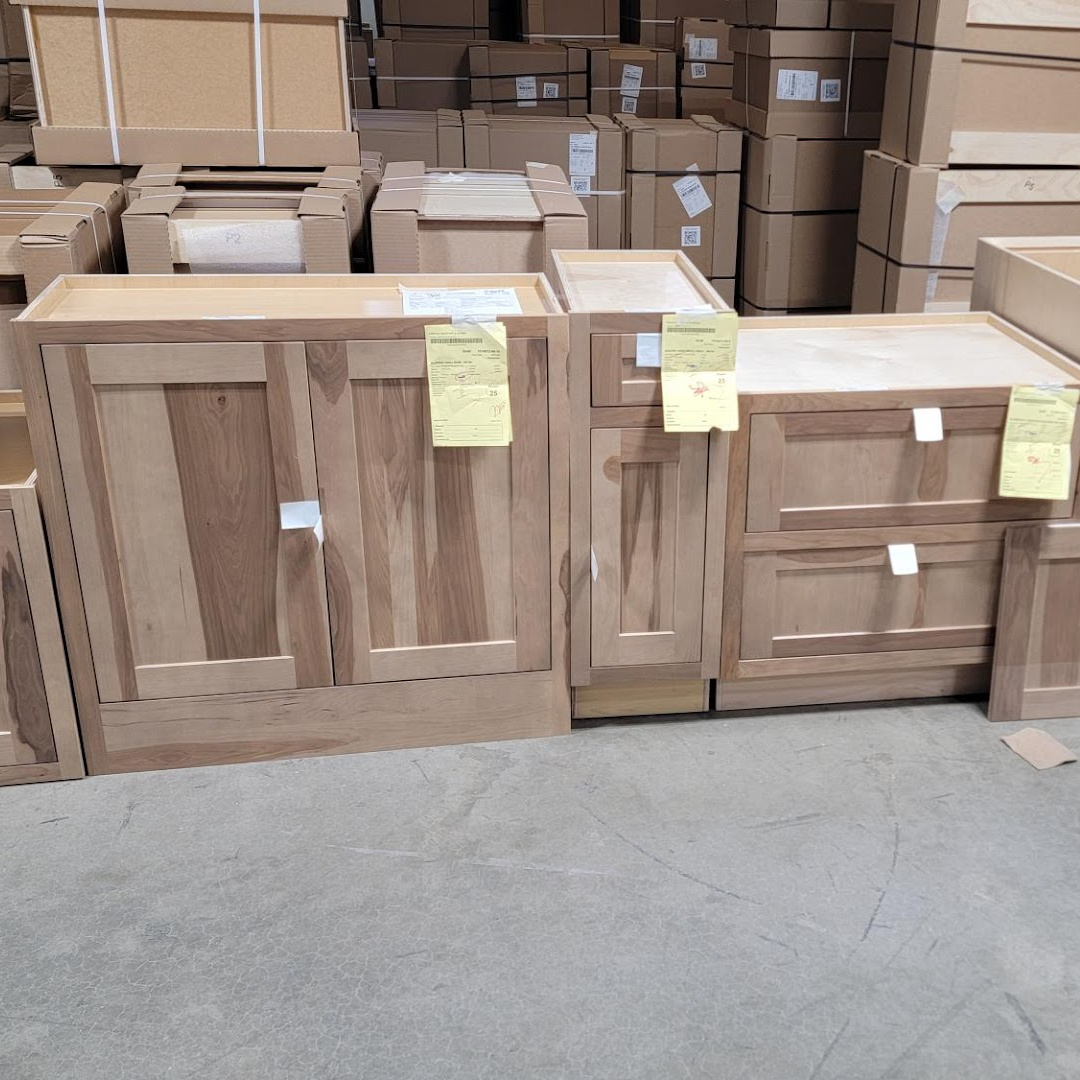 Full height door, standard base, and 2 drawer base in a warehouse setting in hickory with a light brown stain.