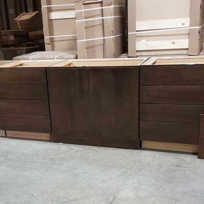 Drawer bases and base with full height doors in a warehouse setting. Finished in a rich brown/red Kona stain.