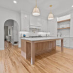 White kitchen perimeter cabinets with an island in washed out light brown Vita stain on Rift White Oak.