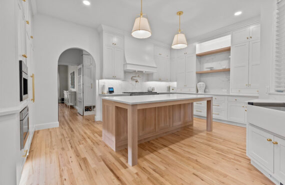 White kitchen perimeter cabinets with an island in washed out light brown Vita stain on Rift White Oak.
