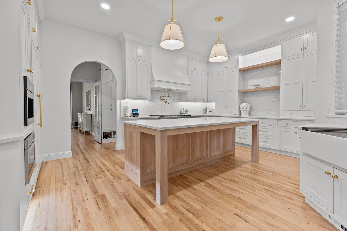 White kitchen perimeter cabinets with an island in washed out light brown Vita stain on Rift White Oak.