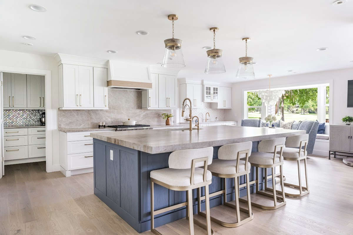 Kitchen with white perimeter and blue island cabinets.
