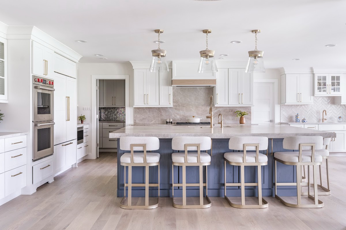 Kitchen with white perimeter and blue island cabinets.
