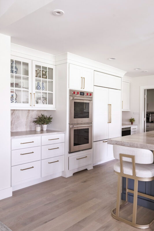 Kitchen with white perimeter and blue island cabinets.
