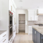 Kitchen with white perimeter and blue island cabinets.