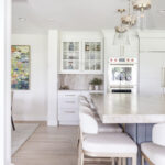 Kitchen with white perimeter and blue island cabinets.