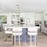 Kitchen with white perimeter and blue island cabinets.