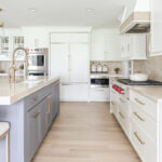 Kitchen with white perimeter and blue island cabinets.