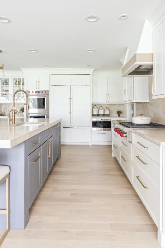 Kitchen with white perimeter and blue island cabinets.