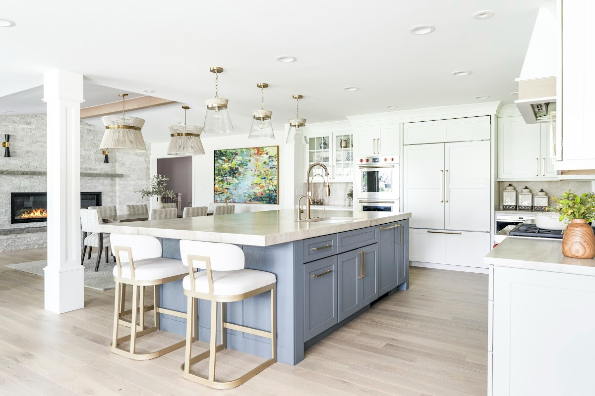 Kitchen with white perimeter and blue island cabinets.