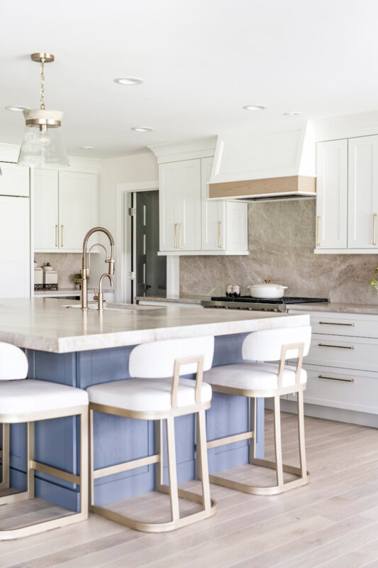 Kitchen with white perimeter and blue island cabinets.