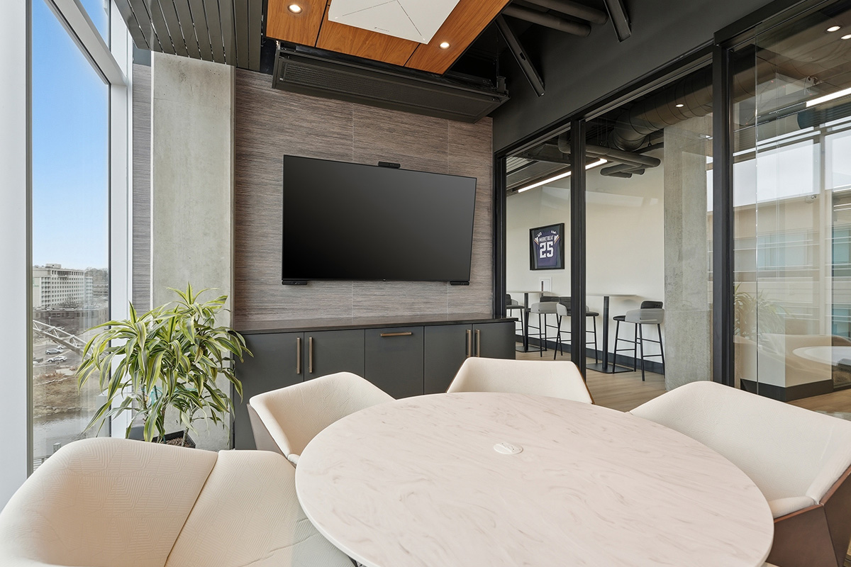 Conference room table and tv above gray cabinets.
