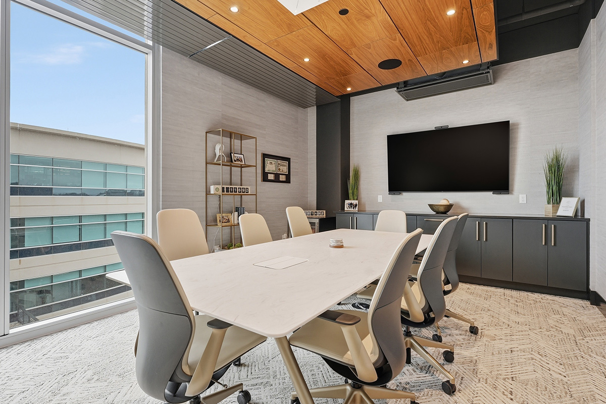 Conference room table and tv above gray cabinets.