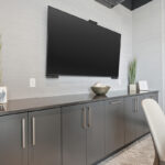 Conference room tv above gray cabinets.