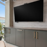 Conference room tv above gray cabinets.