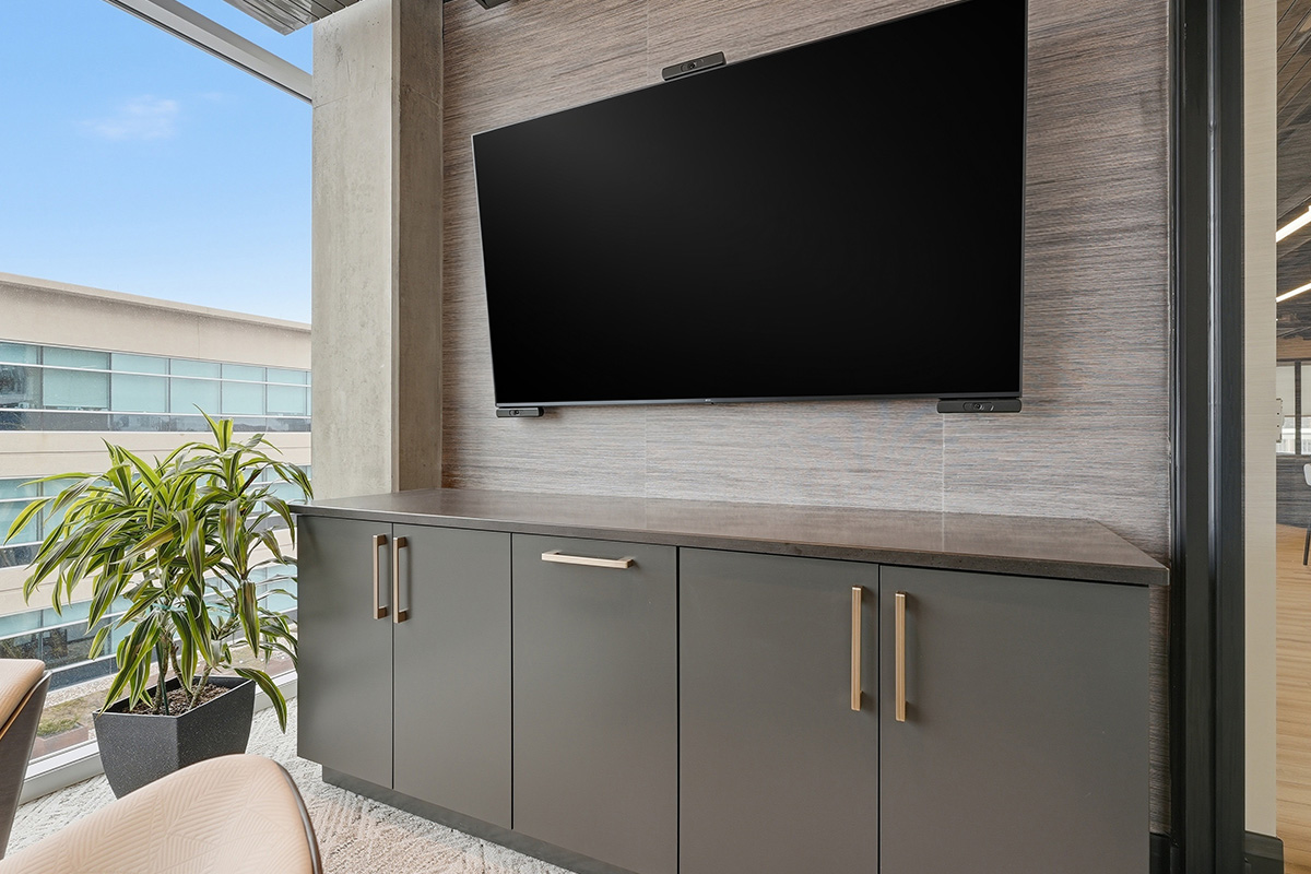 Conference room tv above gray cabinets.