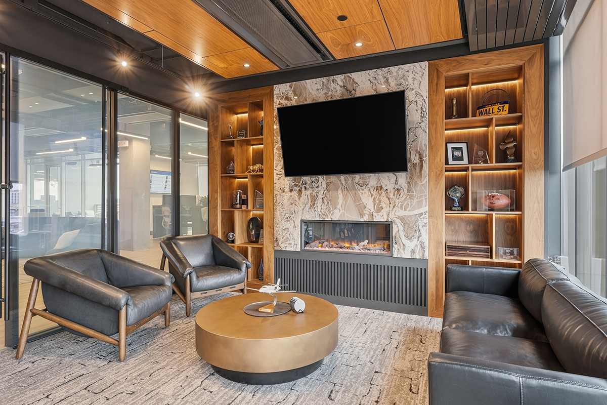 Lounge area speakeasy with bar and fireplace with tv.