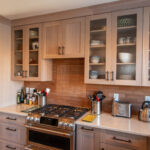 Quartersawn White Oak kitchen in a light Pampas finish with small island and stainless steel appliances.