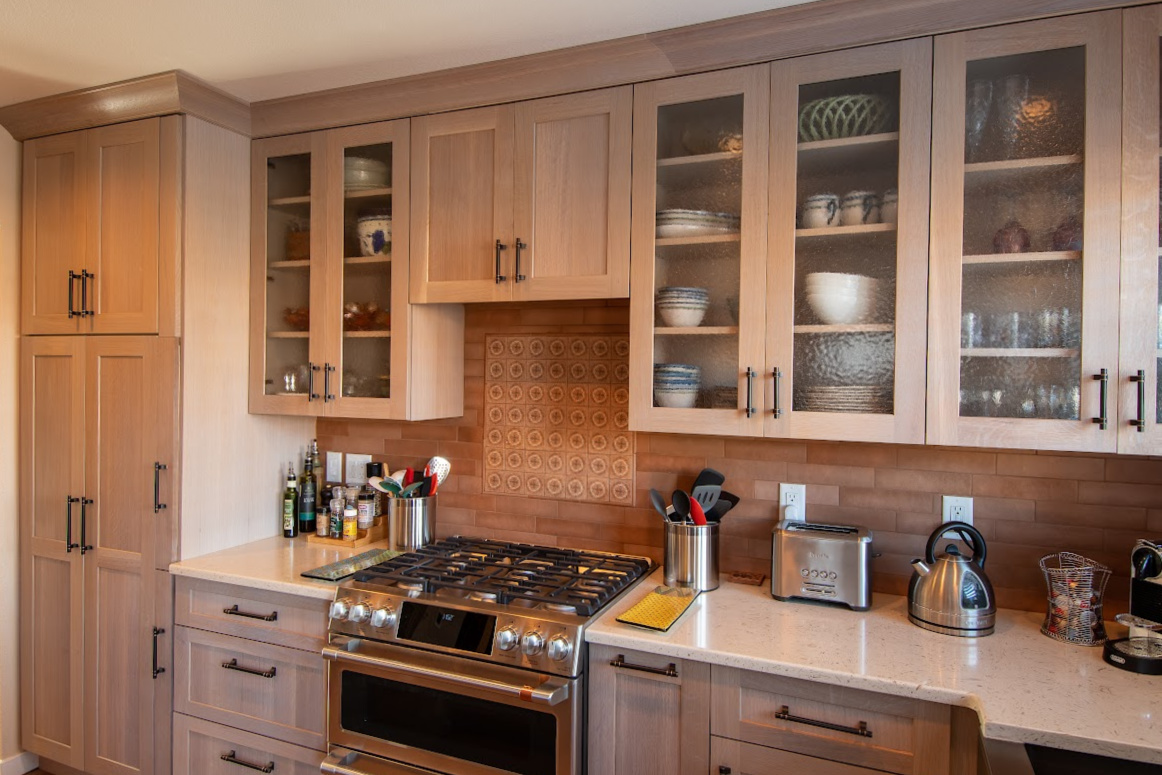 Quartersawn White Oak kitchen in a light Pampas finish with small island and stainless steel appliances.