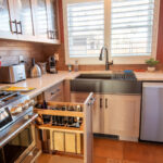 Quartersawn White Oak kitchen in a light Pampas finish showing a pulled out utensil storage accessory.
