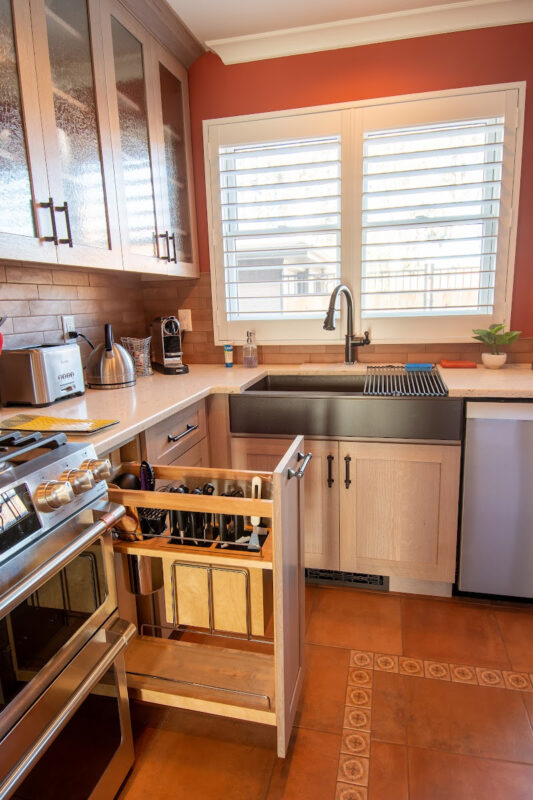 Quartersawn White Oak kitchen in a light Pampas finish showing a pulled out utensil storage accessory.