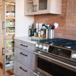 Quartersawn White Oak kitchen in a light Pampas finish showing a pulled out spice storage kits.