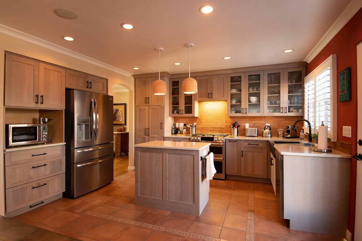 Quartersawn White Oak kitchen in a light Pampas finish with small island and stainless steel appliances.