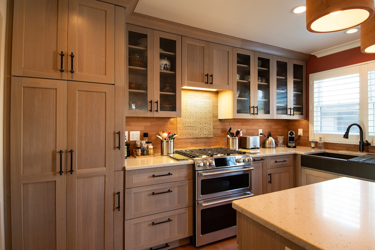 Quartersawn White Oak kitchen in a light Pampas finish with small island and stainless steel appliances.