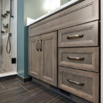 Brown stained bathroom vanity next to a glass steam shower.