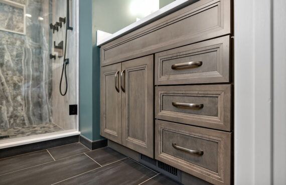 Brown stained bathroom vanity next to a glass steam shower.