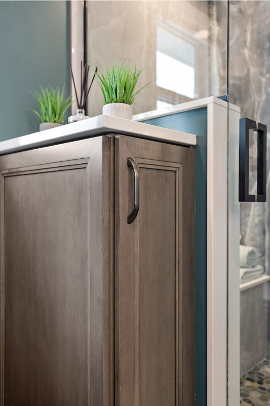 Brown stained bathroom vanity next to a glass steam shower.