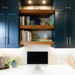 Emerald blue office space with brown stained floating shelves