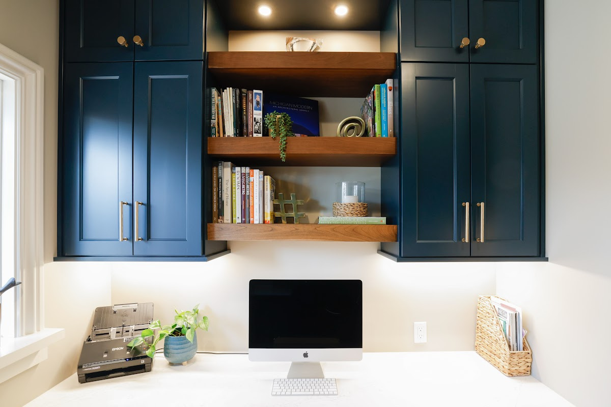 Emerald blue office space with brown stained floating shelves