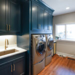 Emerald blue laundry and office space with dog crate cabinet.