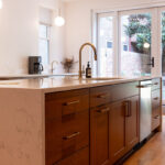 Cherry kitchen cabinets with a red Sienna stain. Shows the island with sink.