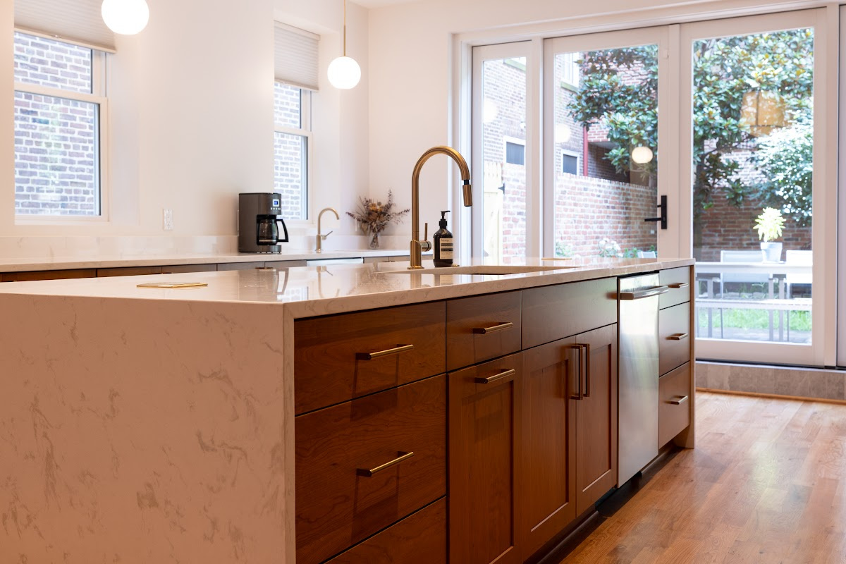 Cherry kitchen cabinets with a red Sienna stain. Shows the island with sink.