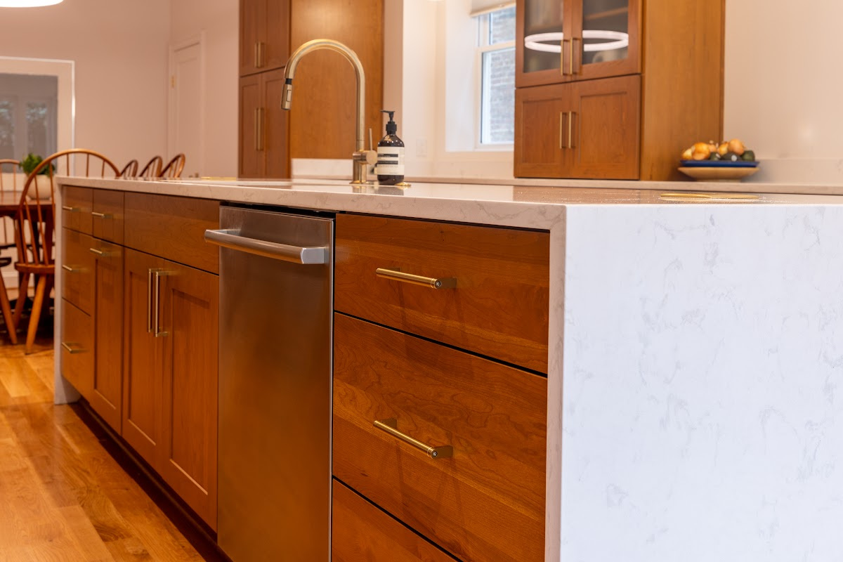 Cherry kitchen cabinets with a red Sienna stain. Shows the island with sink.