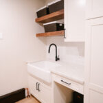 White laundry room cabinets with sink.