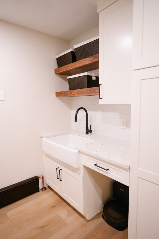 White laundry room cabinets with sink.