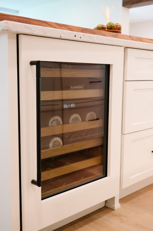 White wine cooler door covering a under counter wine cooler.