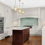 White kitchen perimeter cabinets with a dark cherry island.
