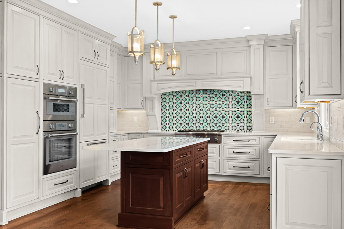White kitchen perimeter cabinets with a dark cherry island.